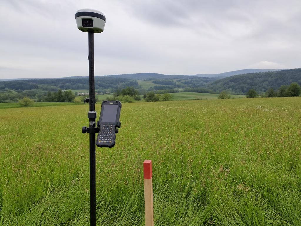 Odbiornik GNSS RTK z kontrolerem na terenie budowy